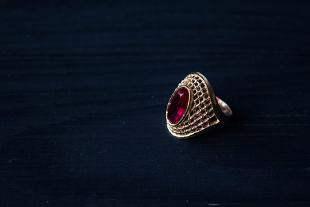 Golden ring with red stone isolated on a black backgroundの写真素材