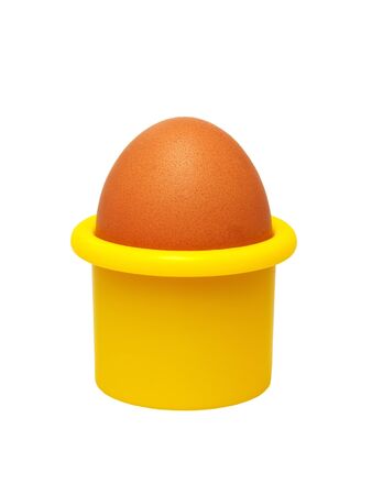 Fresh hen's egg in a yellow eggcup (isolated).の写真素材