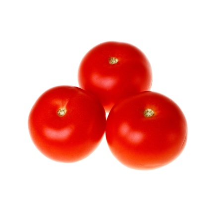 Three fresh tomatoes on white background close-up (isolated).の写真素材