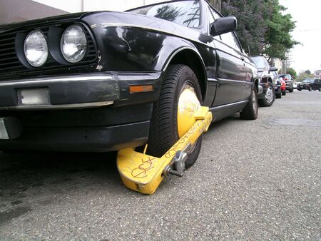Busted: the car was booted for multiple parking violationsの写真素材