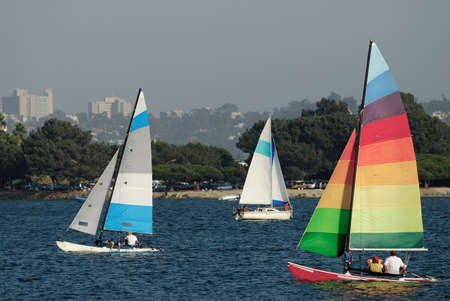 Two yachts and a catamaran are sailing in a Mission Bay, California on a nice summer afternoon.の写真素材