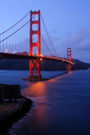 Golden Gate Bridge as seen from Fort Point overlook is glowing in the dusk after a winter storm