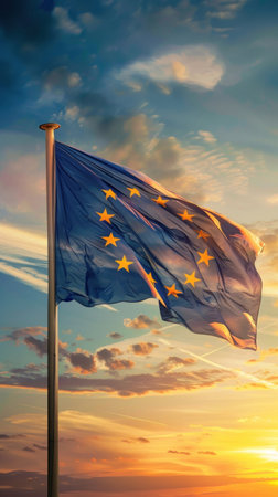 Flag of European Union waving in the breeze against a sunset sky. Banner with EU flag, Europe Day, vertical poster. Highの素材