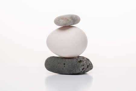 White egg and zen stones on white background