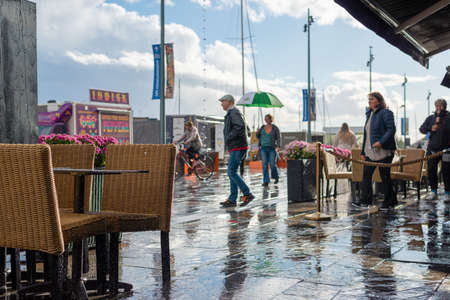 Oslo.Oslo/Norway-09.17.2020: Rainy day in Oslo, Aker Brygge. People walking with umbrella.のeditorial素材