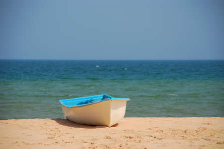 Boat on a sandy beach in sunny day の写真素材