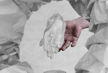 person throwing used protective gear rubber/plastic gloves in to garbage can with the point of view from the canの写真素材