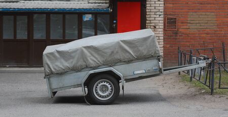 A small cargo trailer for a car strapped to the fenceの写真素材