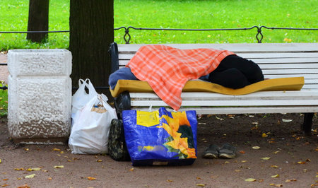 Sleeping on a bench homeless, Aleksandrovskiy garden, Saint-Petersburg, Russia September 2019のeditorial素材