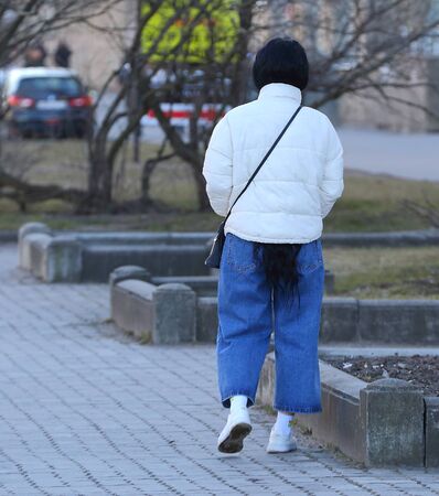 A girl in a white jacket with long black hairの写真素材