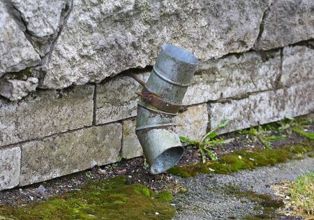 A piece of gray tin drainpipe on the wallの写真素材