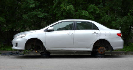 Silver passenger car without wheels on the street