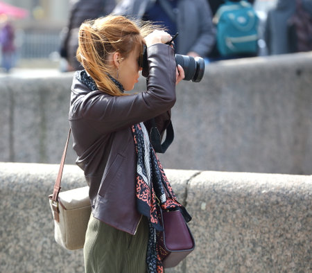 Blonde girl photographer on the street, Nevsky Prospekt, Saint Petersburg, Russia, April 2021のeditorial素材