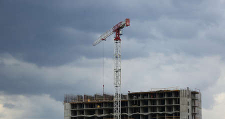 A crane on the construction of a house on a cloudy dayの写真素材