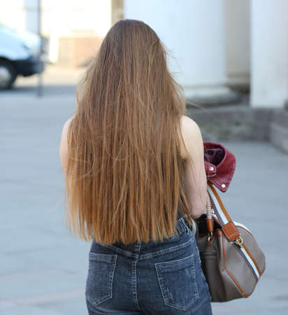 Girl with loose fluffy long brown hair on the streetの写真素材
