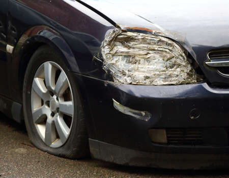 A broken car headlight sealed with sticky tape