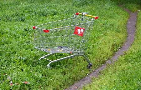 Abandoned in the grass metal trolley from the supermarketの写真素材