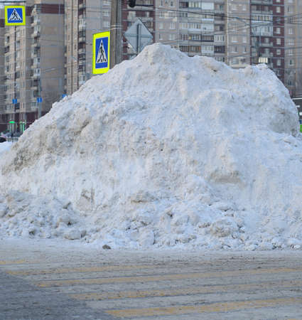 A big pile of snow removed on the streetの写真素材
