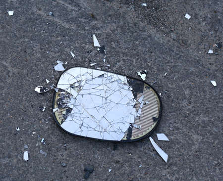 Broken car mirror lying on the asphaltの写真素材