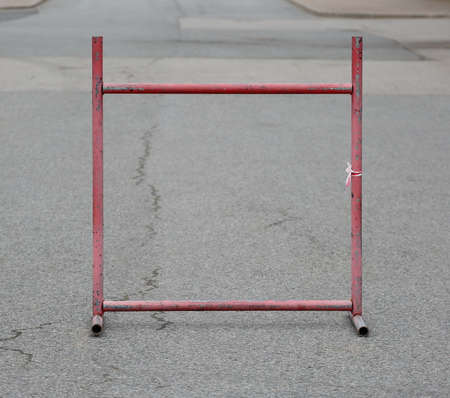 Red metal barrier on asphalt
