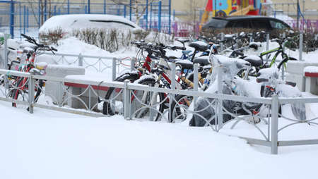 Snow-covered bicycle parking in the courtyard of the houseの写真素材