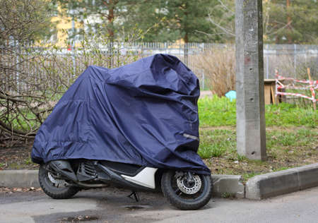 Motorcycle covered with a cover in bad weatherの写真素材