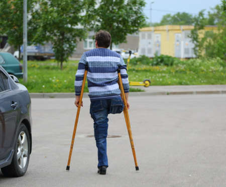 One-legged man with crutches on a walk