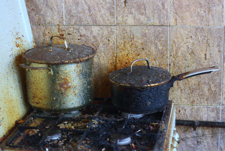 <p>Dirty neglected gas stove with two old dirty pots</p>の写真素材