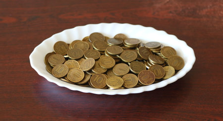 Yellow ten-ruble coins on a white oval dishの写真素材