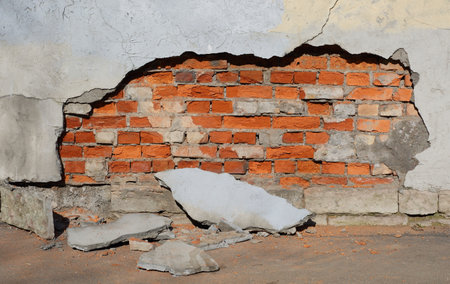 A red brick wall with crumbling plasterの写真素材