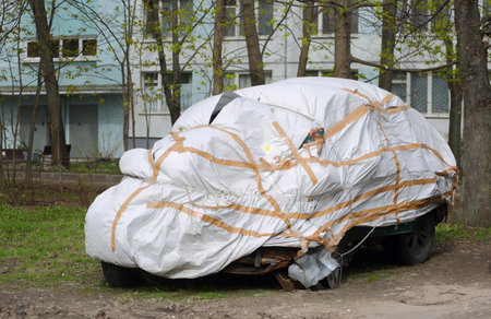 The broken car is covered with a white coverの写真素材