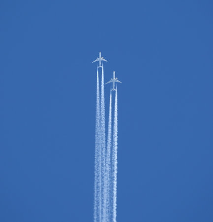 Two jet two-turbine aircraft in flight on blue sky backgroundの写真素材