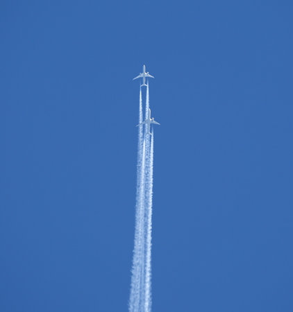 Two jet two-turbine aircraft in flight on blue sky background