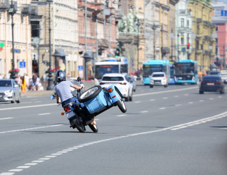 A stunt motorcyclist rides a motorcycle with a sidecar on two wheelsの写真素材