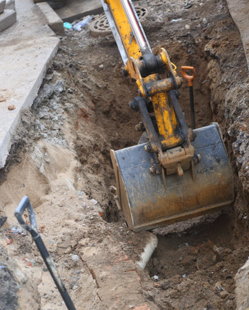 Excavator bucket at the bottom of the excavated ditchの写真素材