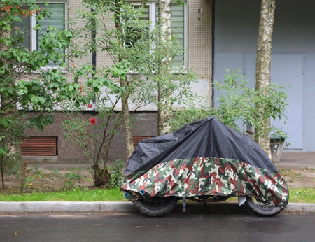 Motorcycle covered with a cover in bad weatherの写真素材