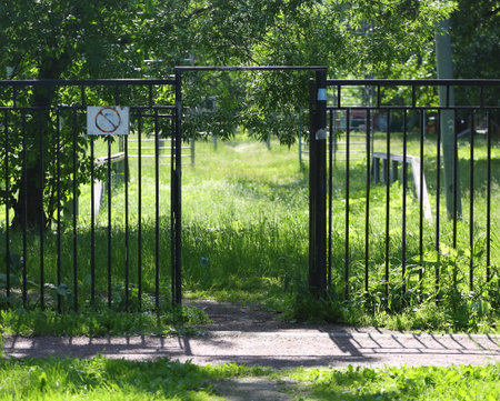 A passage through a lattice fence to a grassy sports fieldの写真素材