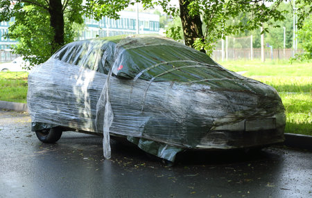 A broken gray car wrapped in plastic after an accidentの写真素材