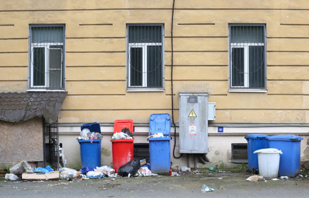 Trash cans are placed under the windows of a residential buildingの写真素材