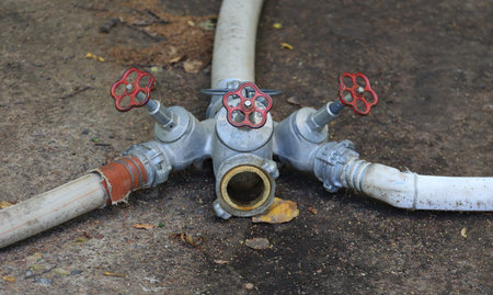 A water splitter with soft pipes lies on the ground