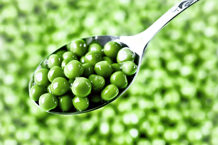 wet green peas on the spoonの写真素材