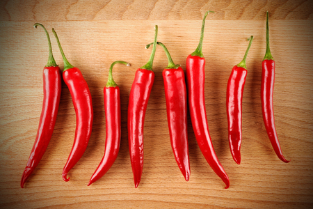 closeup red hot peppers on wood boardの写真素材