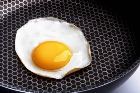 Closeup photo of fried egg on the pan surfaceの写真素材