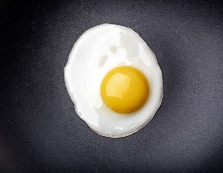 Closeup photo of fried egg on the pan surfaceの写真素材