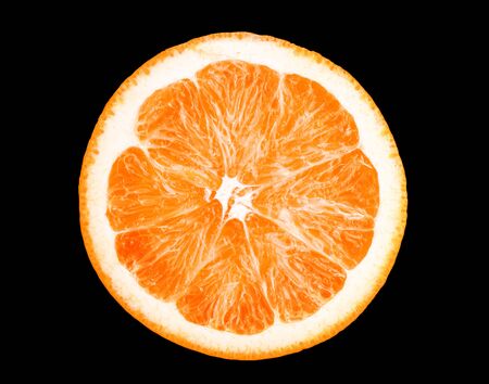 Macro photo of slice of orange fruit isolated on black backgroundの写真素材