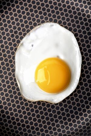 Closeup photo of fried egg on the pan surfaceの写真素材