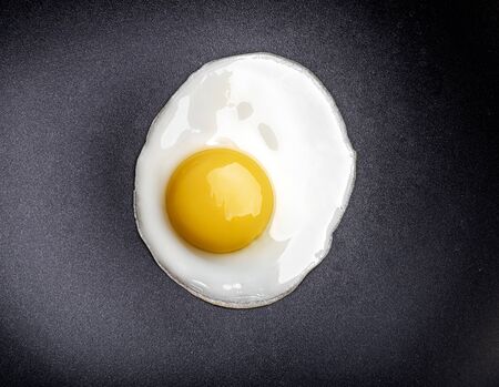 Closeup photo of fried egg on the pan surfaceの写真素材