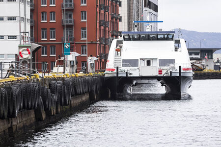 Passenger catamaran at the pier with old tiresの写真素材