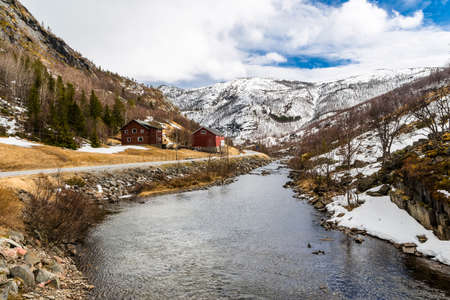 River with beautiful rocky shores and houses in the mountains  Norwayの写真素材