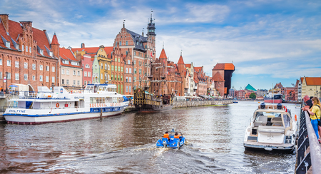 GDANSK, POLAND - AUGUST 02, 2017: Facades of buildings on the embankment of the river with pleasure boats and yachts, an excursion pirate ship and the construction of the XV century - Zhurav, combining several functions - the city gate, defensive tower anのeditorial素材